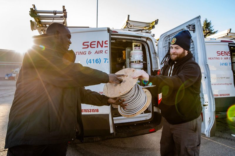 Sensible technicians loading equipment beside the service van